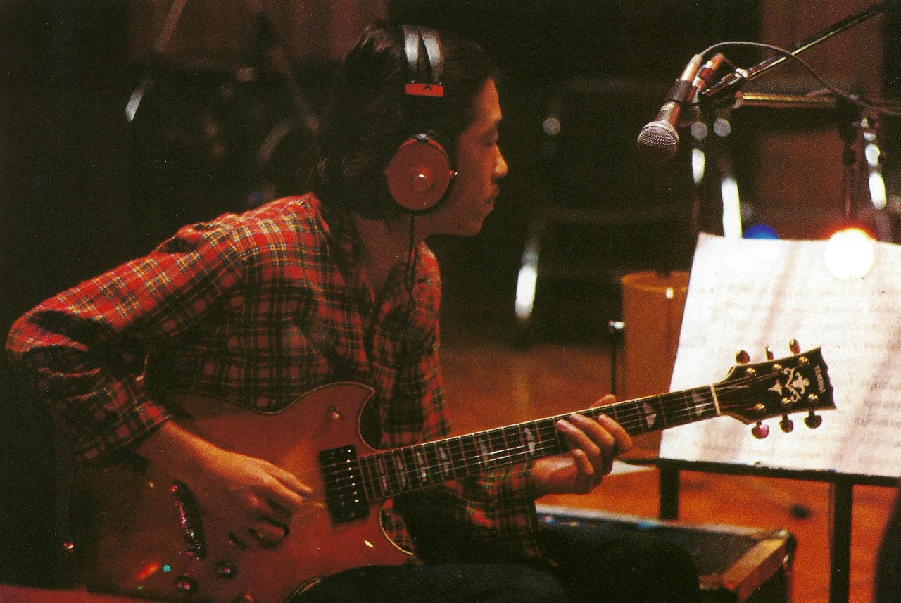 Takanaka seated with the red SG1000 during a Rainbow Goblins recording session